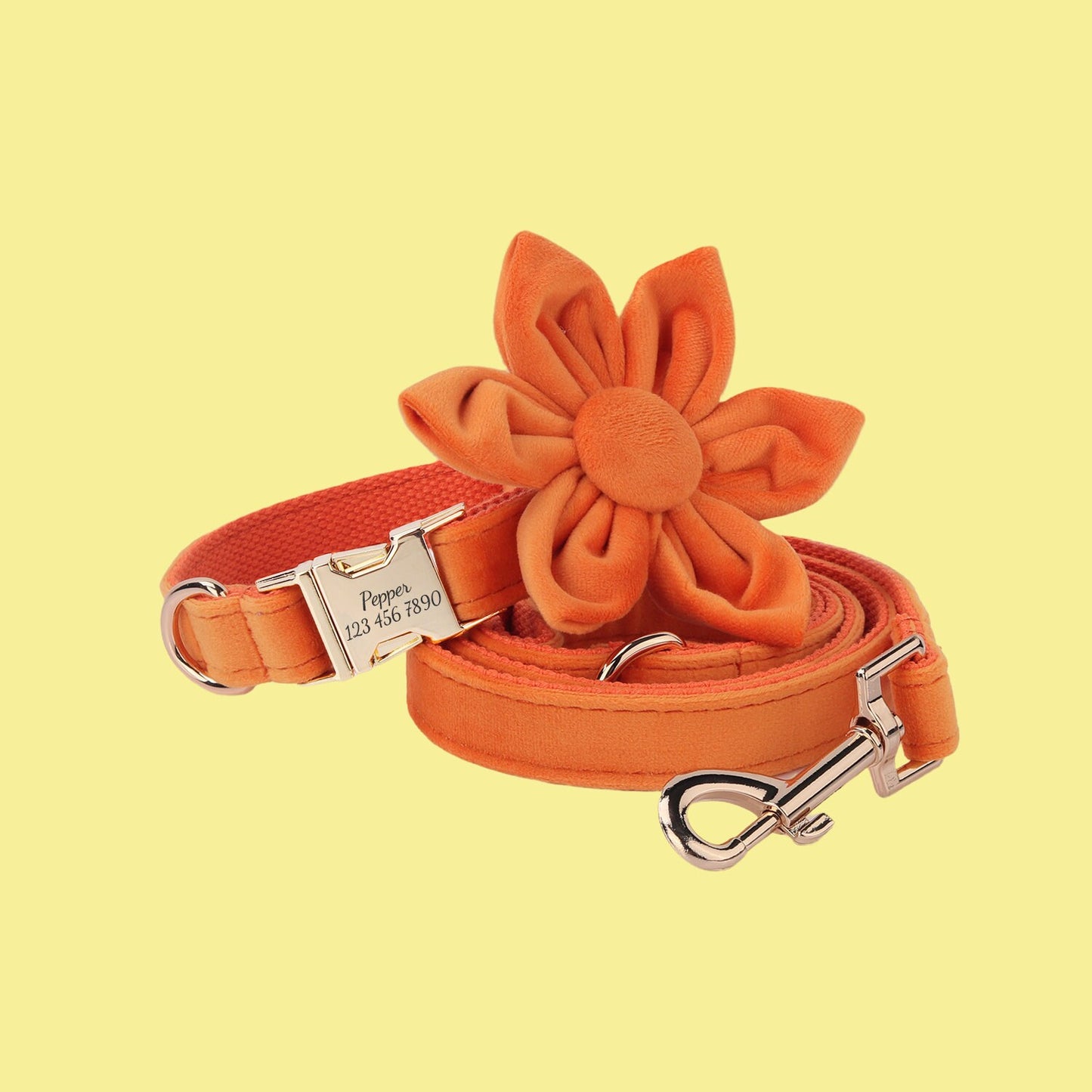 an orange dog leash with a flower on it