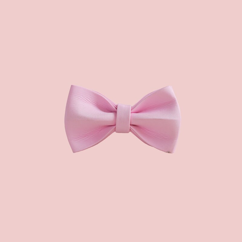 a pink bow tie on a white wall