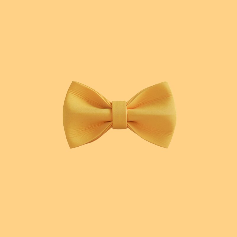 a yellow bow tie on a white wall