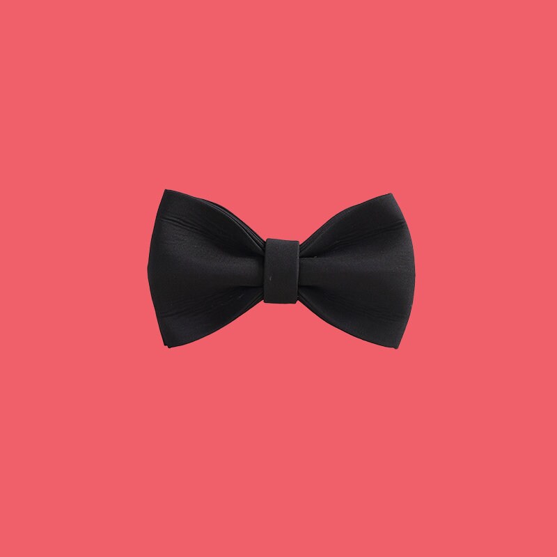 a black bow tie on a white wall