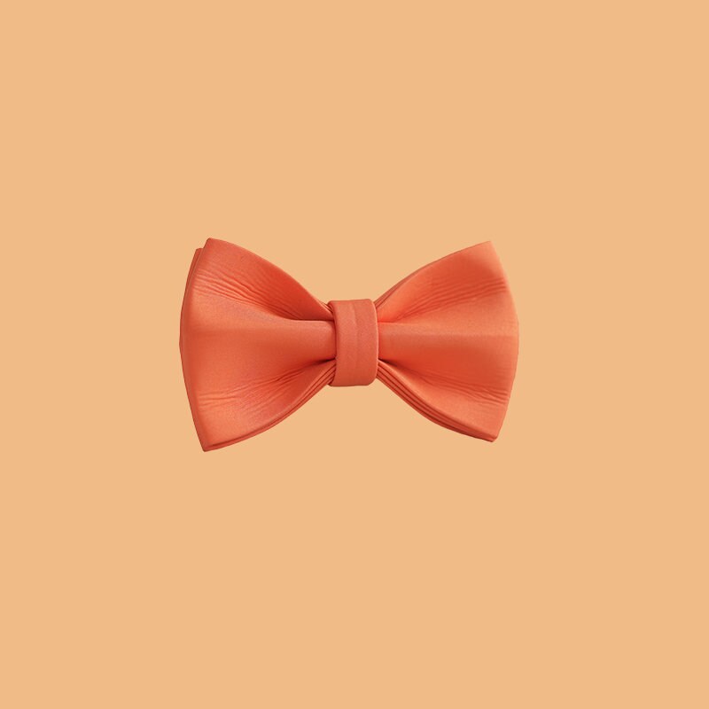 an orange bow tie on a white wall