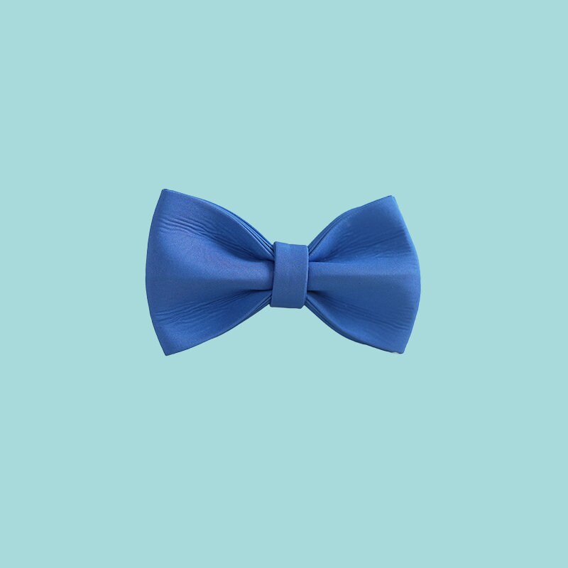 a blue bow tie on a white wall